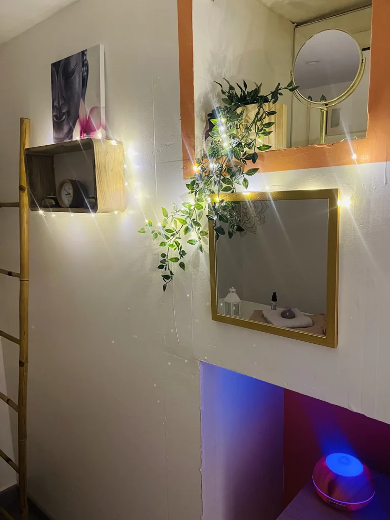 Miroir doré, guirlande lumineuse et diffuseur dans l’institut